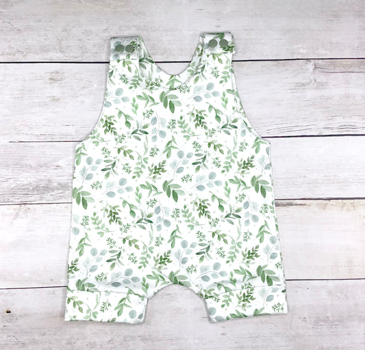 Summer short romper with green leaves on a white background
