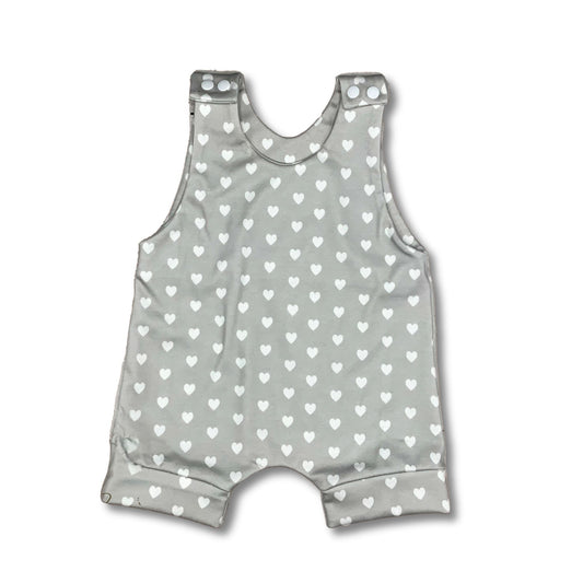 Cute short summer romper with small white hearts on a light grey background with white snaps,