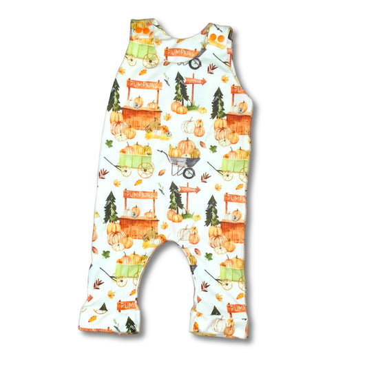 Fall themed long romper for baby and toddler.  Print features a roadside pumpkin stand and wagon loads of pumpkins